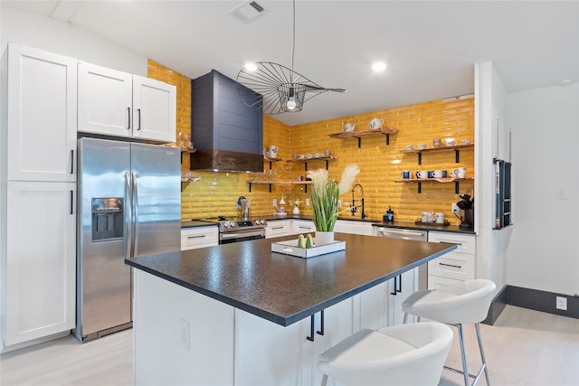 kitchen with white cabinets, a kitchen breakfast bar, and stainless steel appliances