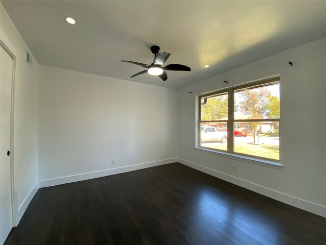 spare room with ceiling fan and dark hardwood / wood-style flooring