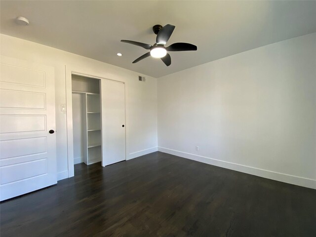 unfurnished bedroom featuring ceiling fan, dark wood-type flooring, and a closet