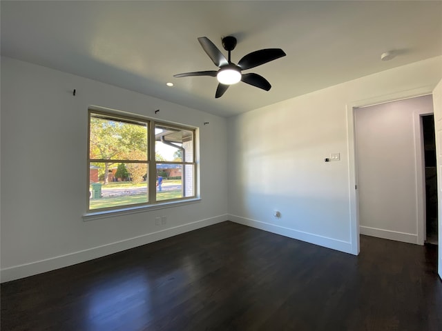 unfurnished room with ceiling fan and dark wood-type flooring