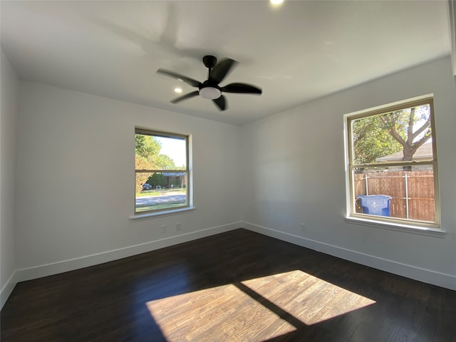 spare room featuring dark hardwood / wood-style floors, a healthy amount of sunlight, and ceiling fan