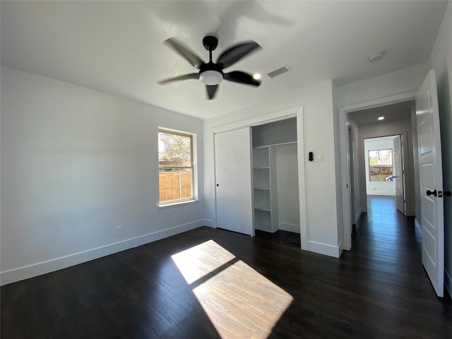 unfurnished bedroom featuring a closet, ceiling fan, and dark wood-type flooring