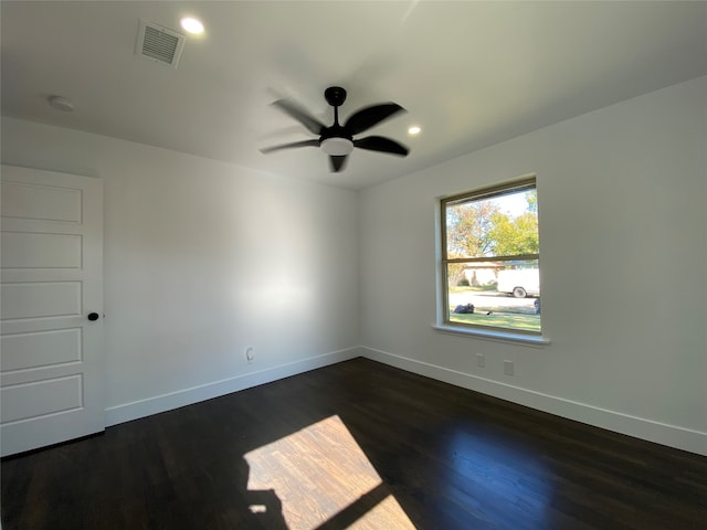 spare room with dark hardwood / wood-style flooring and ceiling fan