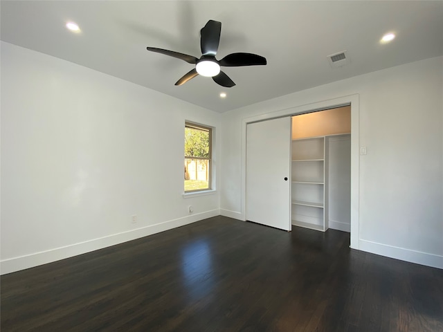 unfurnished bedroom with ceiling fan, a closet, and dark wood-type flooring