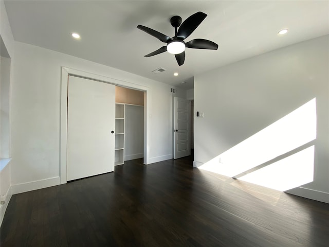 unfurnished bedroom featuring a closet, ceiling fan, and dark wood-type flooring