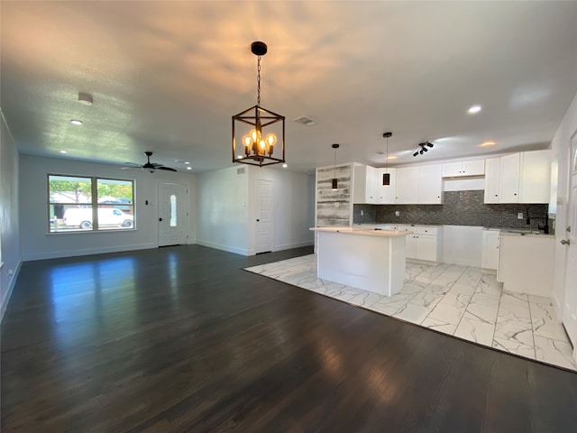 kitchen featuring white cabinets, a center island, hanging light fixtures, and light hardwood / wood-style flooring