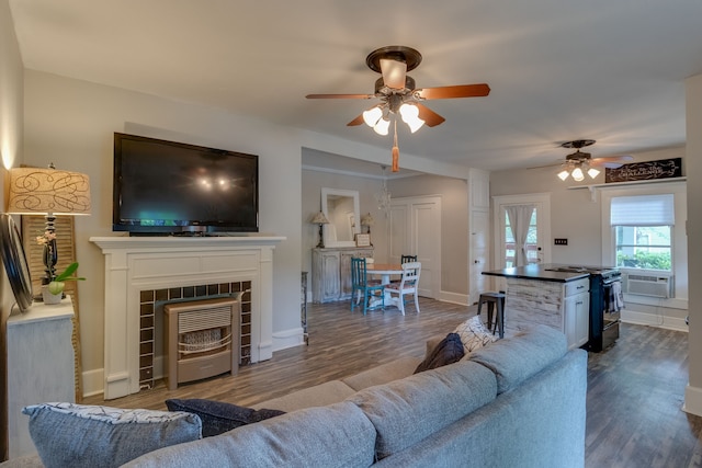 living room featuring a tile fireplace, wood-type flooring, cooling unit, and ceiling fan