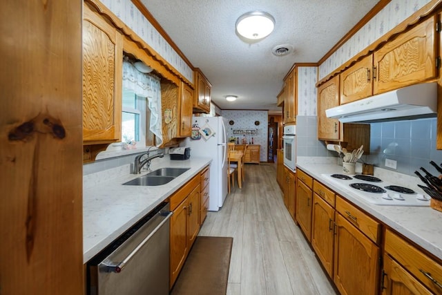 kitchen with crown molding, sink, white appliances, and light wood-type flooring