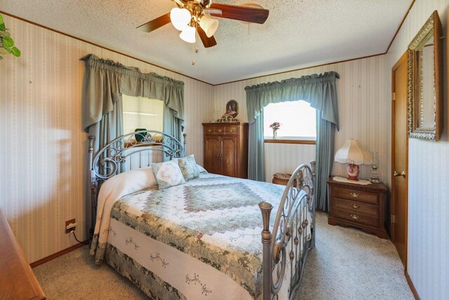 carpeted bedroom with ceiling fan and a textured ceiling