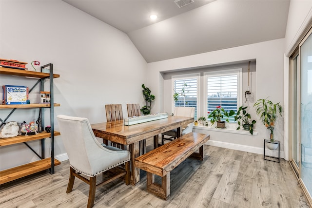 dining space featuring light hardwood / wood-style floors and lofted ceiling