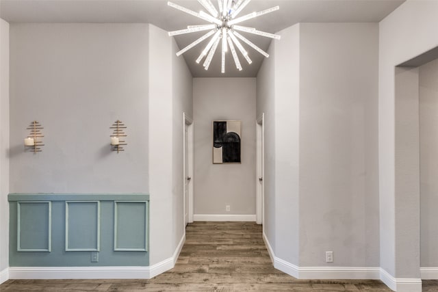 corridor with a chandelier and wood-type flooring