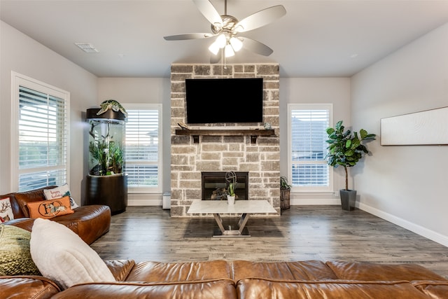 living room with a fireplace, dark hardwood / wood-style flooring, a wealth of natural light, and ceiling fan