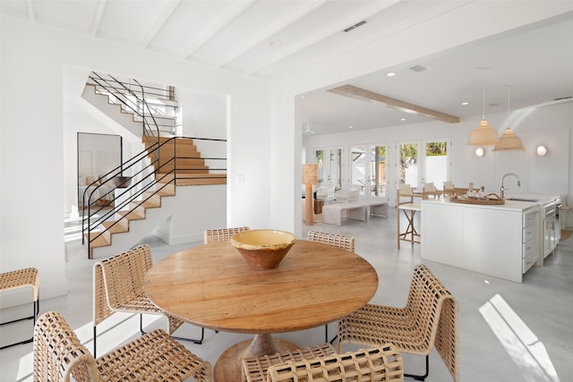 dining area featuring beam ceiling and sink