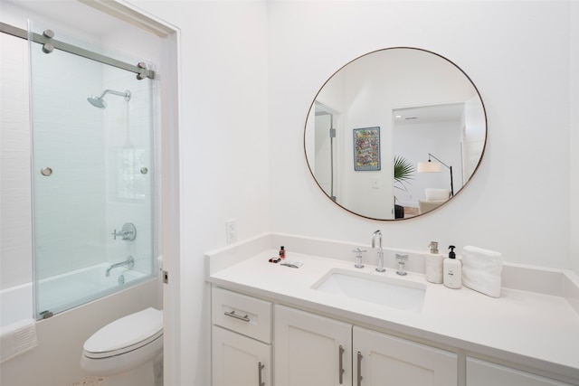 full bathroom featuring combined bath / shower with glass door, vanity, and toilet