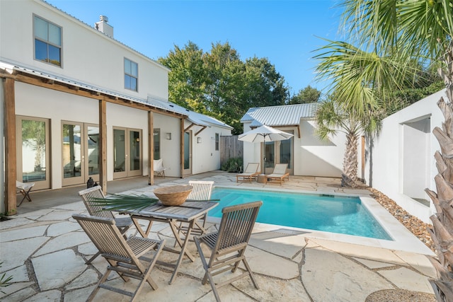 view of swimming pool featuring french doors and a patio