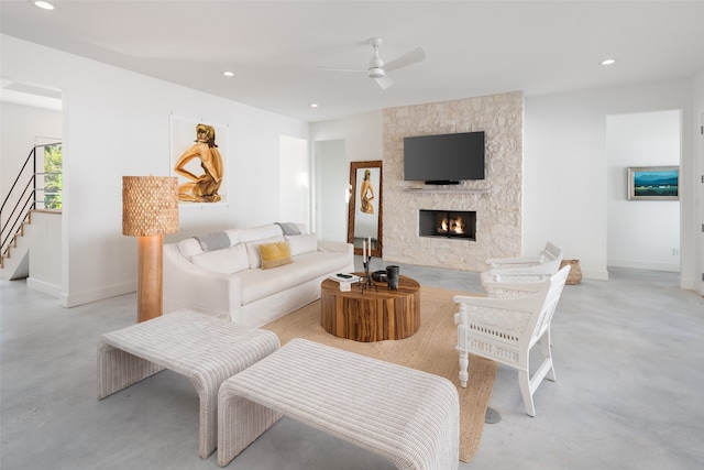 living room with ceiling fan and a stone fireplace