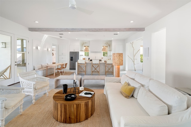 living room featuring ceiling fan and beamed ceiling