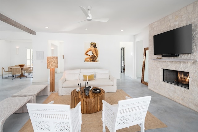 living room featuring ceiling fan and a fireplace