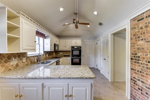 kitchen featuring lofted ceiling, black appliances, sink, light stone counters, and kitchen peninsula