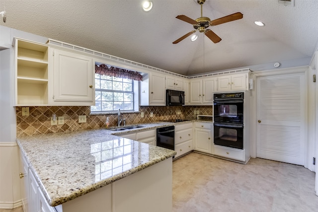 kitchen featuring kitchen peninsula, light stone countertops, sink, and vaulted ceiling