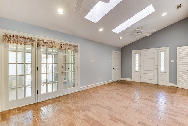 foyer entrance with a skylight, ceiling fan, plenty of natural light, and a textured ceiling