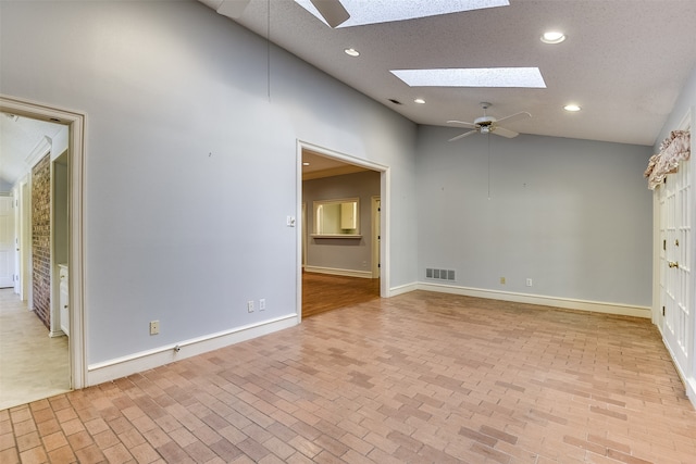 unfurnished room featuring a skylight, ceiling fan, high vaulted ceiling, and a textured ceiling