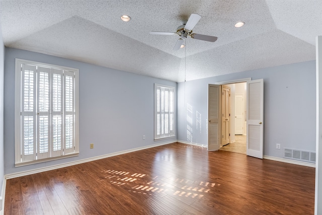 unfurnished room featuring a textured ceiling, vaulted ceiling, ceiling fan, and dark wood-type flooring