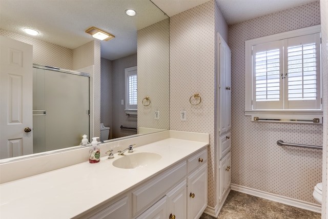 bathroom with a shower with door, vanity, and toilet