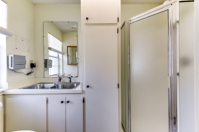 bathroom featuring a textured ceiling, vanity, and an enclosed shower