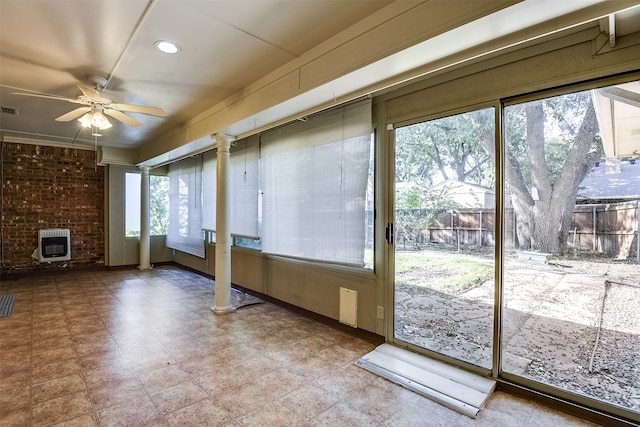 entryway featuring heating unit, ornate columns, plenty of natural light, and ceiling fan