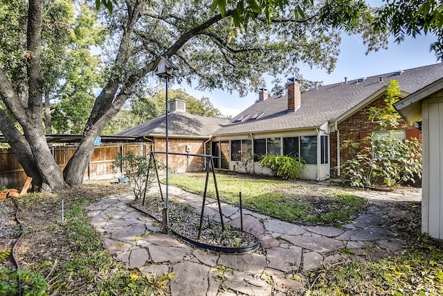 rear view of property with a sunroom and a yard