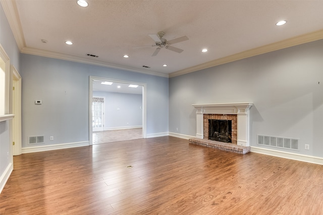 unfurnished living room with ceiling fan, a fireplace, crown molding, and light hardwood / wood-style flooring