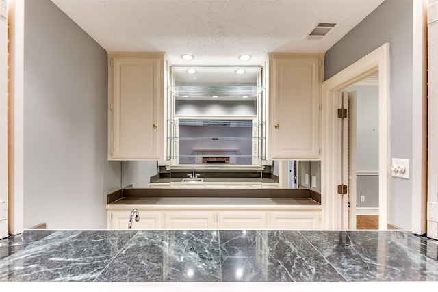 kitchen featuring cream cabinets and a textured ceiling