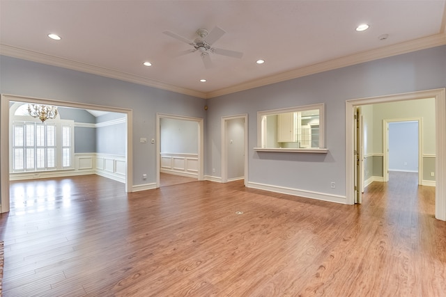 unfurnished living room featuring ornamental molding, ceiling fan with notable chandelier, and light wood-type flooring