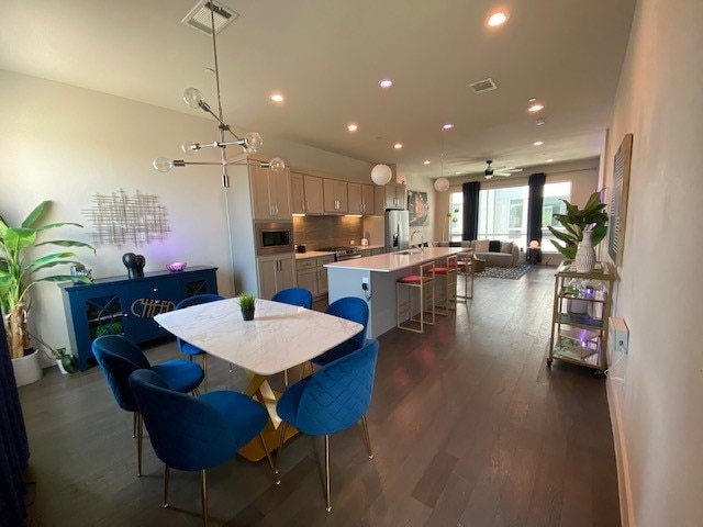 dining area with ceiling fan, dark hardwood / wood-style flooring, and sink