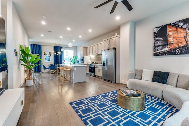 living area with recessed lighting, visible vents, wood finished floors, and a ceiling fan