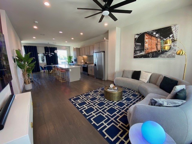 living room with dark hardwood / wood-style floors and ceiling fan