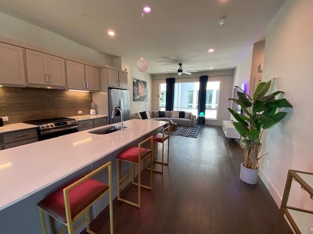 kitchen with gray cabinets, sink, appliances with stainless steel finishes, and dark wood-type flooring