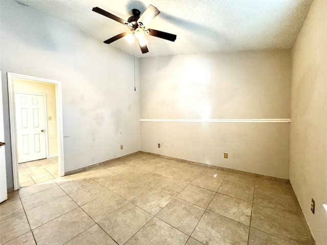 tiled empty room featuring a textured ceiling and ceiling fan