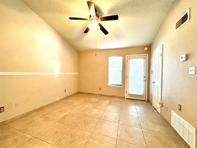 tiled spare room featuring ceiling fan and a textured ceiling