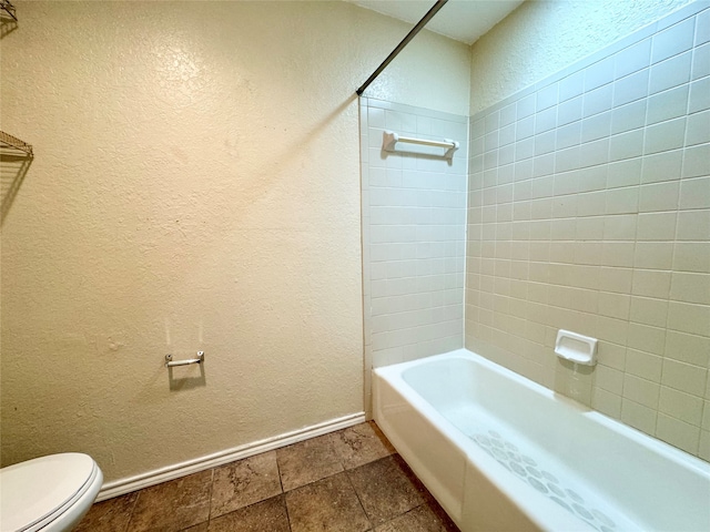 bathroom with tiled shower / bath combo and toilet