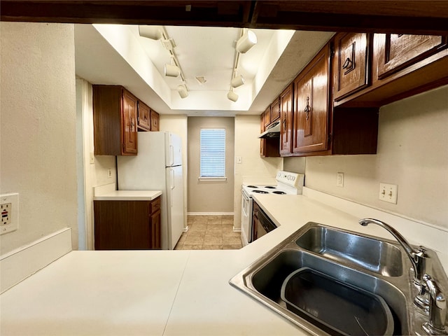 kitchen with light tile patterned floors, white appliances, track lighting, and sink