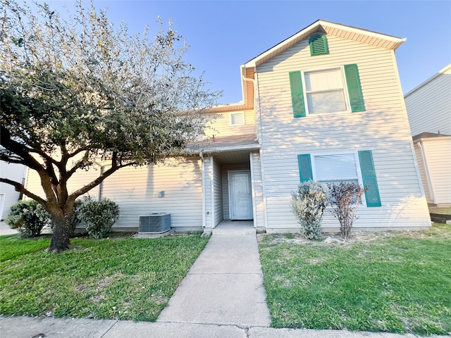 view of front of home with central AC and a front yard