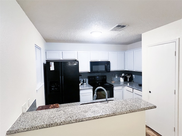 kitchen featuring white cabinetry, sink, light hardwood / wood-style floors, decorative backsplash, and black appliances