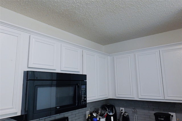 interior details with decorative backsplash, a textured ceiling, and white cabinets