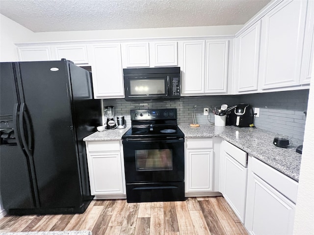 kitchen featuring decorative backsplash, light wood-type flooring, light stone counters, black appliances, and white cabinets