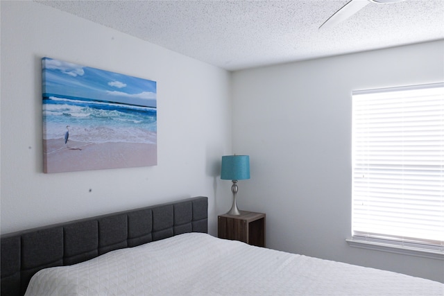 bedroom featuring ceiling fan and a textured ceiling