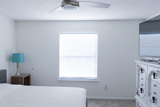 bedroom with multiple windows, light carpet, a textured ceiling, and ceiling fan