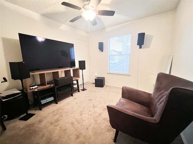 carpeted living room with ceiling fan and a textured ceiling