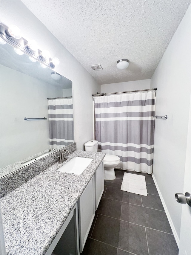 bathroom featuring a shower with curtain, tile patterned floors, a textured ceiling, toilet, and vanity